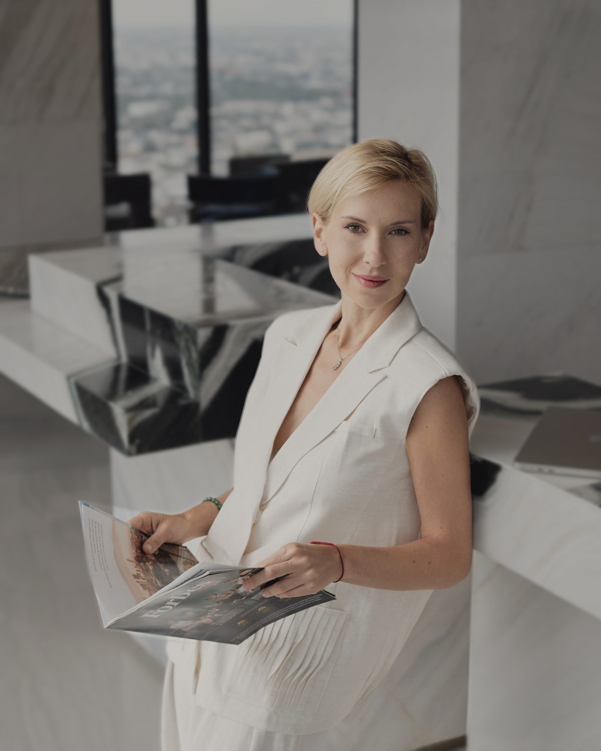 Katerina Andreeva holding an open magazine in a light interior.