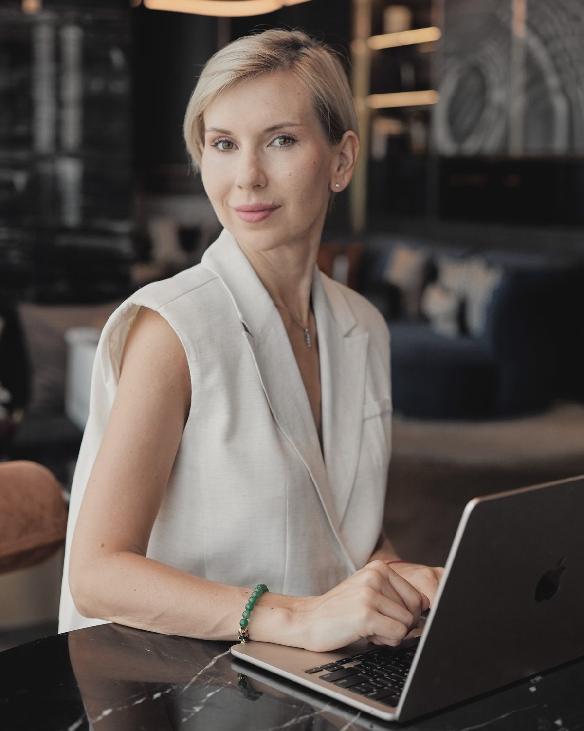 Katerina Andreeva seated at a table with an open laptop.